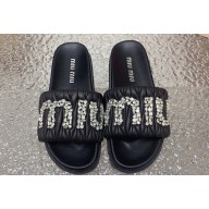 Miu Miu Matelassé nappa leather slides Black with Crystal Logo 2024